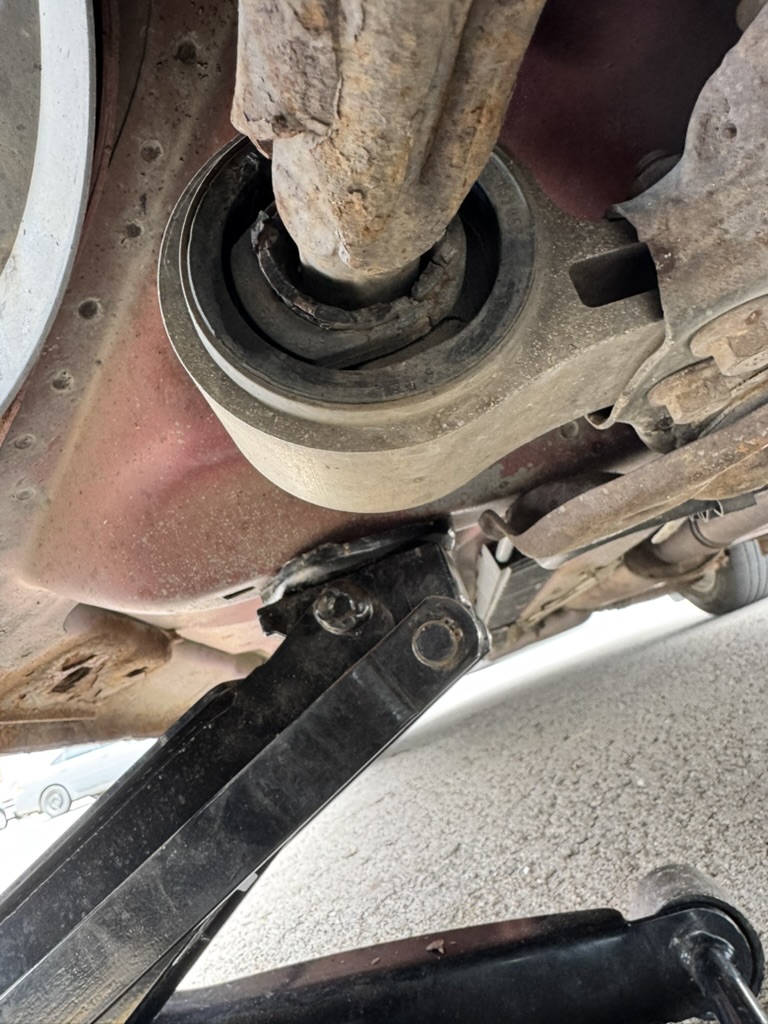 Close-up inspection of a worn suspension bushing